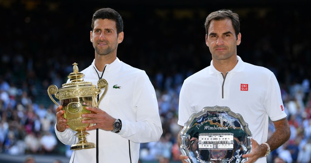 Djokovic and Federer pose with their trophies in Wimbledon in 2019